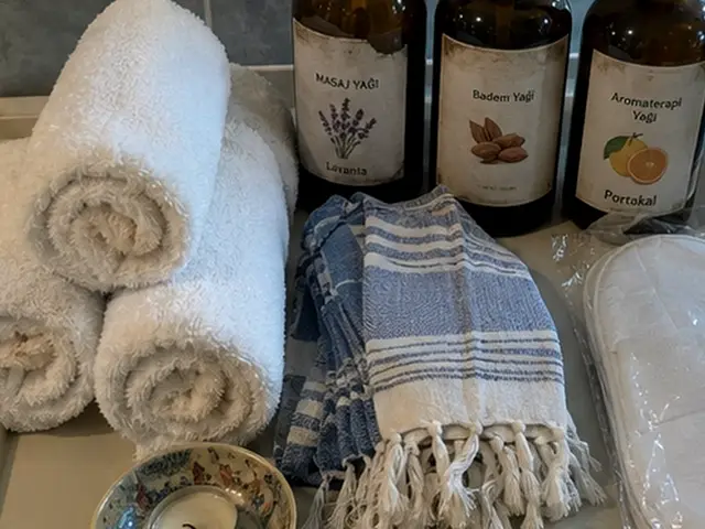 Rulo havlular, mavi peştemal ve aromaterapi yağları — Çırağan, Masaj Salonun